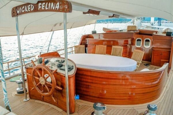 wicked-felina-gulet-photo18 Luxurious wooden yacht deck with a hot tub and spacious seating area, perfect for Gulet charter in Turkey. Beautiful maritime vessel offering premium comfort and scenic views.